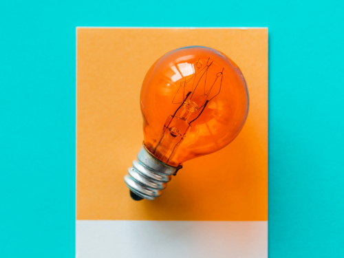 Glühbirne auf orang-blauem Hintergrund